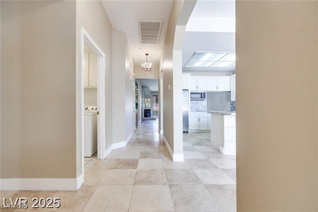 2723 Seabridge Dr, Las Vegas, NV 89121 - hall featuring a chandelier, washer / dryer, and light tile patterned floors