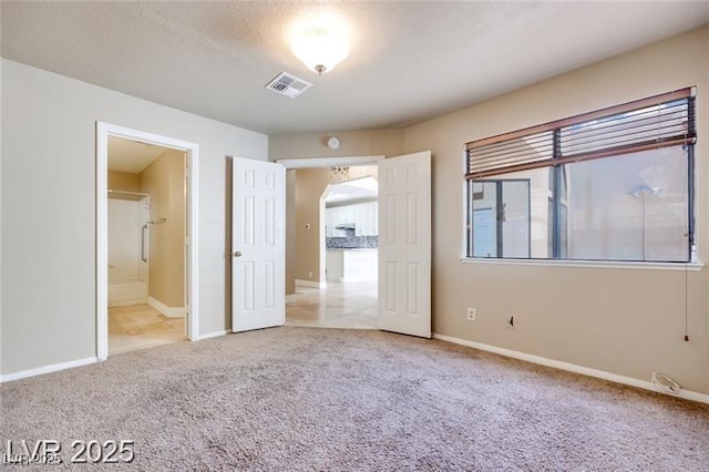 2723 Seabridge Dr, Las Vegas, NV 89121 - unfurnished bedroom featuring carpet, multiple windows, arched walkways, and ensuite bath