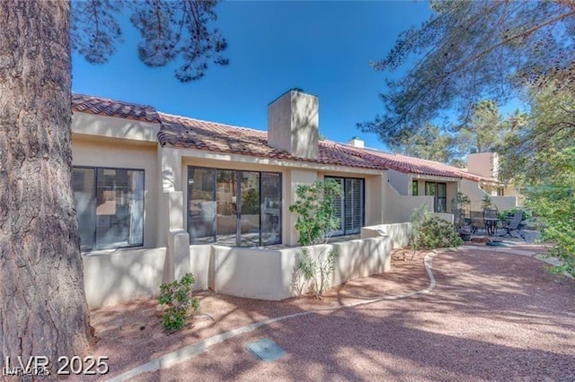 2723 Seabridge Dr, Las Vegas, NV 89121 - back of property with a chimney, stucco siding, a patio area, and a tile roof