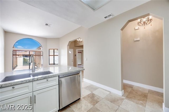2723 Seabridge Dr, Las Vegas, NV 89121 - kitchen featuring dishwasher, arched walkways, light stone counters, and white cabinetry