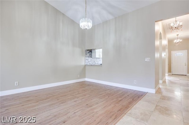 2723 Seabridge Dr, Las Vegas, NV 89121 - spare room featuring a chandelier, arched walkways, and light wood-type flooring
