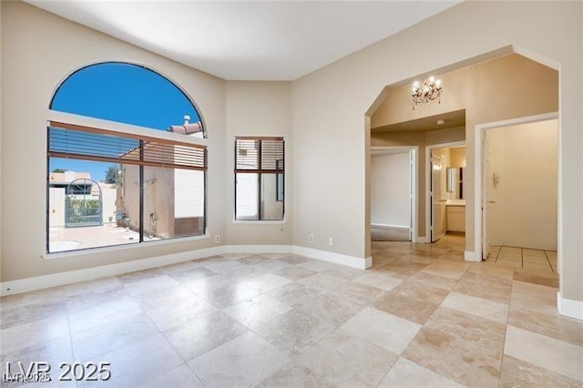 2723 Seabridge Dr, Las Vegas, NV 89121 - empty room featuring arched walkways and a chandelier