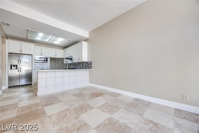 2723 Seabridge Dr, Las Vegas, NV 89121 - kitchen featuring appliances with stainless steel finishes, backsplash, white cabinetry, a peninsula, and light countertops