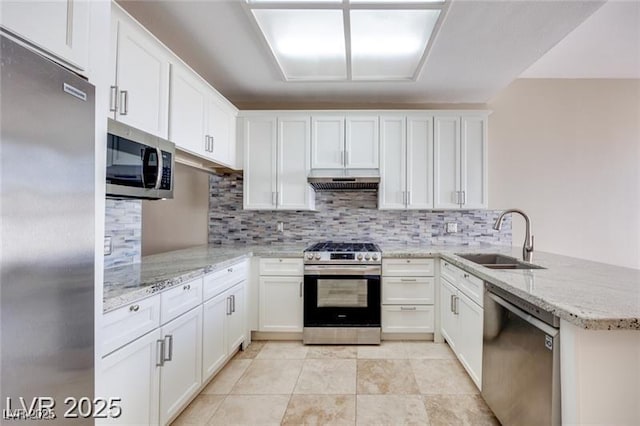 2723 Seabridge Dr, Las Vegas, NV 89121 - kitchen with appliances with stainless steel finishes, a peninsula, white cabinetry, under cabinet range hood, and tasteful backsplash