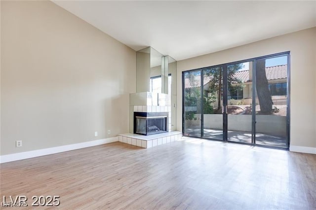 2723 Seabridge Dr, Las Vegas, NV 89121 - unfurnished living room featuring wood finished floors, a tile fireplace, and lofted ceiling