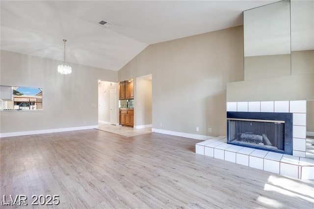 2723 Seabridge Dr, Las Vegas, NV 89121 - unfurnished living room with a chandelier, wood finished floors, high vaulted ceiling, and a fireplace