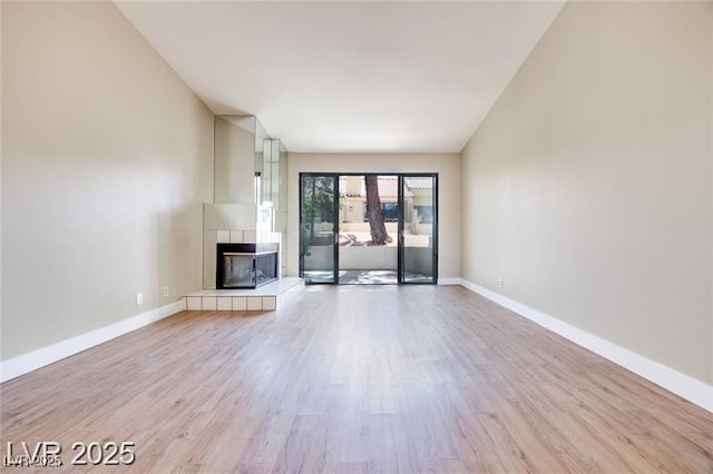 2723 Seabridge Dr, Las Vegas, NV 89121 - unfurnished living room with a tiled fireplace and light wood finished floors