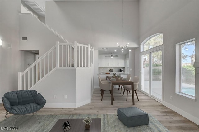 2212 Warm Walnut Dr, Las Vegas, NV 89134 - living area featuring a high ceiling, light wood-style floors, a ceiling fan, stairs, and a chandelier