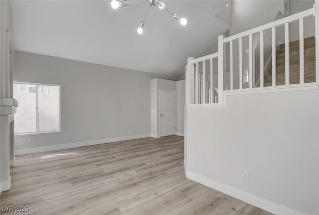 2212 Warm Walnut Dr, Las Vegas, NV 89134 - unfurnished living room with lofted ceiling, wood finished floors, and stairway
