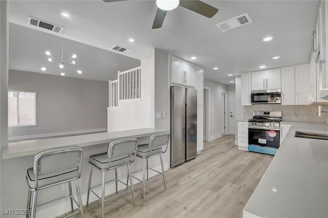 2212 Warm Walnut Dr, Las Vegas, NV 89134 - kitchen featuring stainless steel appliances, a ceiling fan, white cabinetry, light wood-style flooring, and light countertops