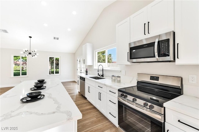 811 Spyglass Ln, Las Vegas, NV 89107 - kitchen with appliances with stainless steel finishes, light wood-style flooring, white cabinetry, high vaulted ceiling, and recessed lighting