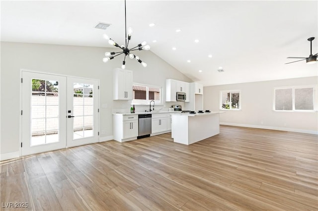811 Spyglass Ln, Las Vegas, NV 89107 - kitchen with stainless steel appliances, open floor plan, french doors, light countertops, and white cabinets