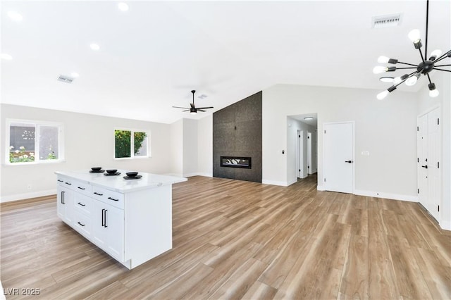 811 Spyglass Ln, Las Vegas, NV 89107 - unfurnished living room featuring a chandelier, lofted ceiling, ceiling fan, light wood finished floors, and a tile fireplace
