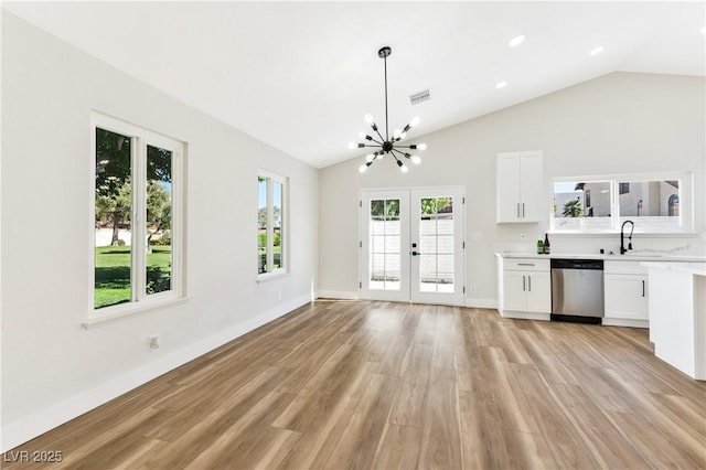 811 Spyglass Ln, Las Vegas, NV 89107 - unfurnished living room featuring french doors, light wood-style floors, lofted ceiling, and a chandelier