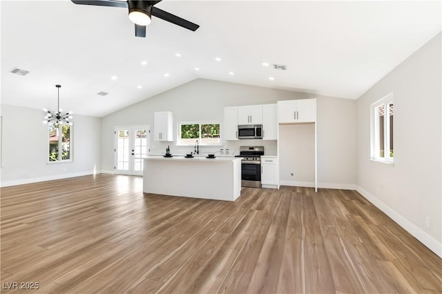 811 Spyglass Ln, Las Vegas, NV 89107 - unfurnished living room featuring a ceiling fan, light wood finished floors, a chandelier, high vaulted ceiling, and recessed lighting