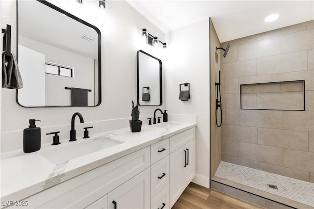 811 Spyglass Ln, Las Vegas, NV 89107 - bathroom with double vanity, a tile shower, wood finished floors, and recessed lighting