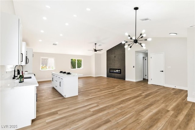 811 Spyglass Ln, Las Vegas, NV 89107 - kitchen with light countertops, open floor plan, white cabinetry, vaulted ceiling, and ceiling fan