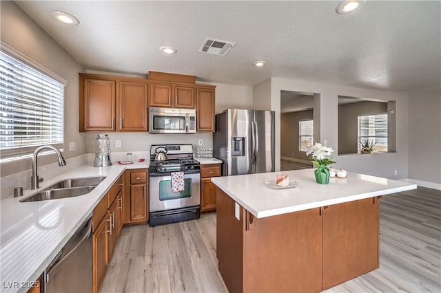 9129 Patrick Henry Ave, Las Vegas, NV 89149 - kitchen featuring stainless steel appliances, brown cabinets, light countertops, a center island, and recessed lighting