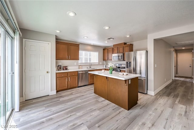 9129 Patrick Henry Ave, Las Vegas, NV 89149 - kitchen featuring appliances with stainless steel finishes, brown cabinets, a breakfast bar area, light countertops, and recessed lighting