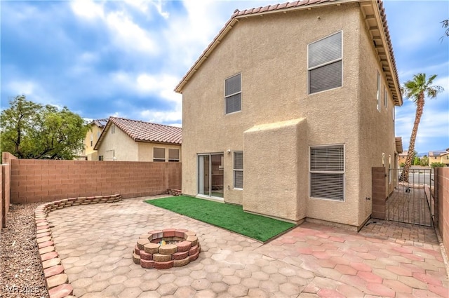 9129 Patrick Henry Ave, Las Vegas, NV 89149 - rear view of house with stucco siding, a fire pit, a patio, and a fenced backyard