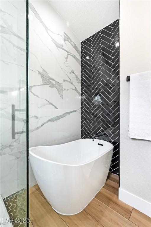 8113 Bay Springs Dr, Las Vegas, NV 89128 - bathroom with tile walls, wood finished floors, a freestanding tub, and a shower stall
