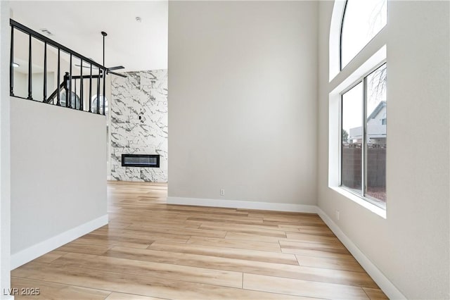 8113 Bay Springs Dr, Las Vegas, NV 89128 - spare room featuring a towering ceiling, wood finished floors, and a fireplace