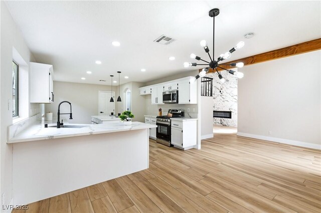 8113 Bay Springs Dr, Las Vegas, NV 89128 - kitchen with appliances with stainless steel finishes, white cabinetry, a chandelier, a peninsula, and recessed lighting