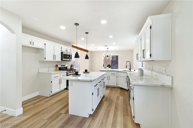 8113 Bay Springs Dr, Las Vegas, NV 89128 - kitchen featuring appliances with stainless steel finishes, light wood-type flooring, white cabinetry, a peninsula, and recessed lighting