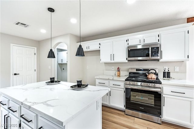 8113 Bay Springs Dr, Las Vegas, NV 89128 - kitchen with appliances with stainless steel finishes, white cabinetry, light wood-type flooring, recessed lighting, and pendant lighting