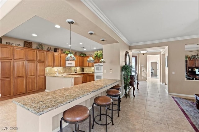 8623 Kennedy Heights Ct, Las Vegas, NV 89131 - kitchen with a center island with sink, white appliances, ornamental molding, a kitchen bar, and brown cabinets