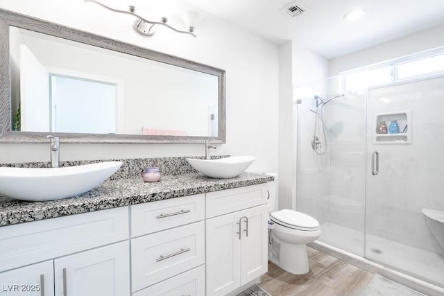 8812 Marble Dr, Las Vegas, NV 89134 - full bathroom featuring a shower stall, double vanity, and wood finished floors