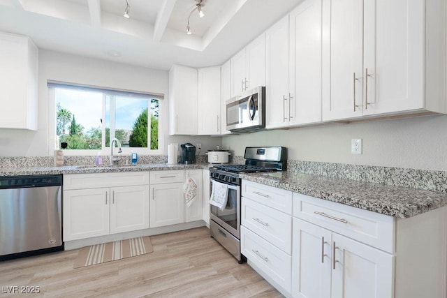 8812 Marble Dr, Las Vegas, NV 89134 - kitchen with appliances with stainless steel finishes, white cabinets, and light stone counters