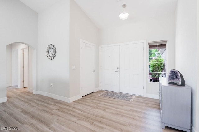 8812 Marble Dr, Las Vegas, NV 89134 - entrance foyer with arched walkways, high vaulted ceiling, and light wood-style flooring