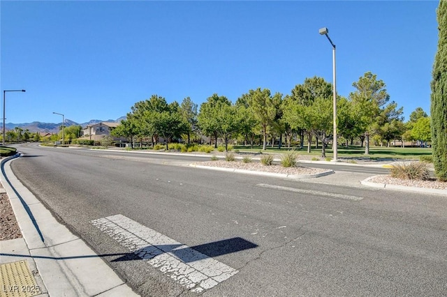1013 Brinkman St, Las Vegas, NV 89138 - view of asphalt road with street lights, curbs, and sidewalks