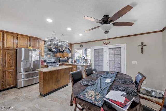 7026 Westpark Ct, Las Vegas, NV 89147 - kitchen with stainless steel appliances, crown molding, brown cabinetry, a kitchen island, and light countertops