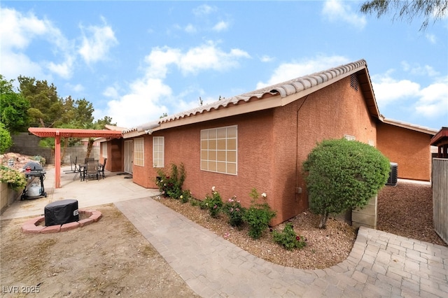 7517 Elk Meadows Ct, Las Vegas, NV 89131 - view of side of property with stucco siding, a patio, an outdoor fire pit, a fenced backyard, and a tile roof