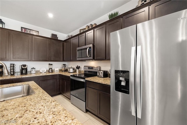 3568 E Malheur Ave, Pahrump, NV 89061 - kitchen featuring stainless steel appliances, dark brown cabinetry, light stone countertops, light tile patterned flooring, and recessed lighting