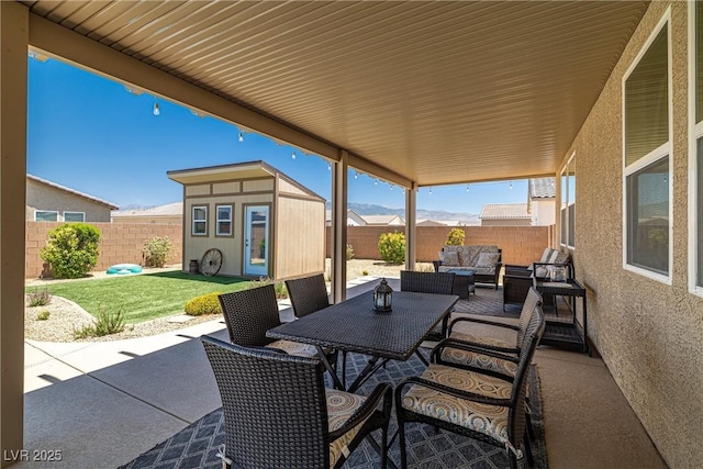 3568 E Malheur Ave, Pahrump, NV 89061 - fenced backyard with an outdoor living space, a patio, an outdoor structure, and outdoor dining area