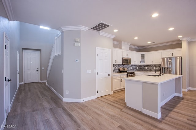 8026 Sunset Creek St, Las Vegas, NV 89113 - kitchen with stainless steel appliances, light wood-type flooring, white cabinets, crown molding, and glass insert cabinets