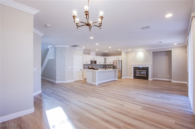 8026 Sunset Creek St, Las Vegas, NV 89113 - unfurnished living room featuring crown molding, recessed lighting, a chandelier, a glass covered fireplace, and light wood-style flooring