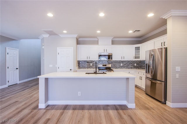 8026 Sunset Creek St, Las Vegas, NV 89113 - kitchen featuring stainless steel appliances, light countertops, ornamental molding, an island with sink, and light wood-type flooring