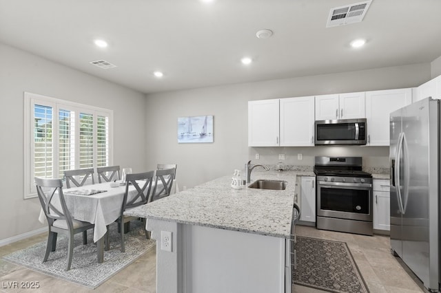4498 Lantern Point Ave, North Las Vegas, NV 89084 - kitchen featuring appliances with stainless steel finishes, a peninsula, white cabinetry, light stone countertops, and recessed lighting