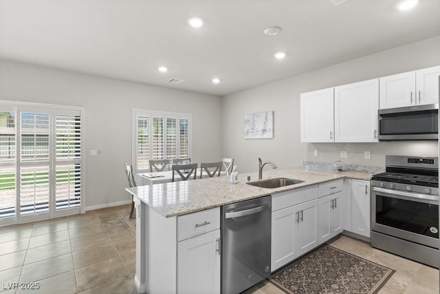 4498 Lantern Point Ave, North Las Vegas, NV 89084 - kitchen with stainless steel appliances, a peninsula, white cabinetry, recessed lighting, and light stone counters