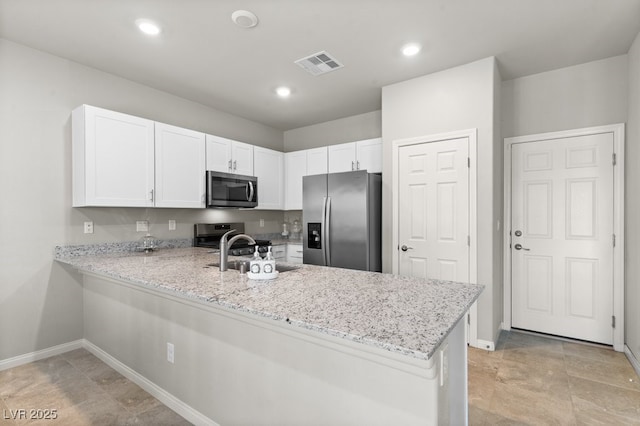 4498 Lantern Point Ave, North Las Vegas, NV 89084 - kitchen with stainless steel appliances, a peninsula, white cabinets, light stone countertops, and recessed lighting