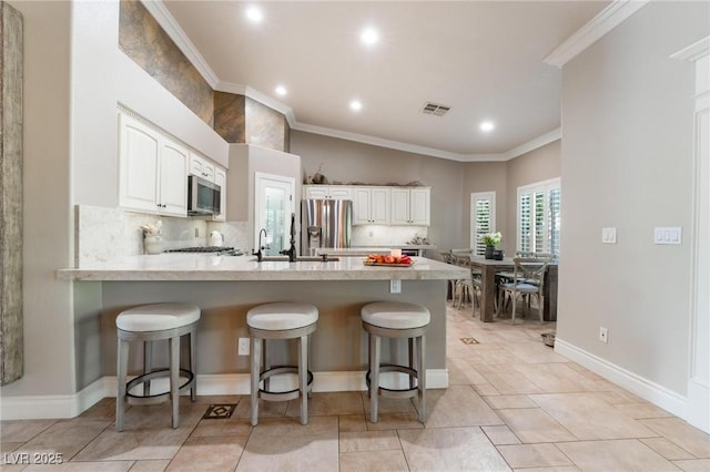 4014 Trapani Pl, Las Vegas, NV 89141 - kitchen featuring stainless steel appliances, a peninsula, white cabinetry, light countertops, and crown molding