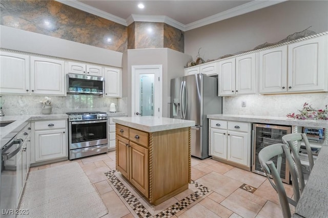 4014 Trapani Pl, Las Vegas, NV 89141 - kitchen with stainless steel appliances, ornamental molding, backsplash, white cabinets, and beverage cooler