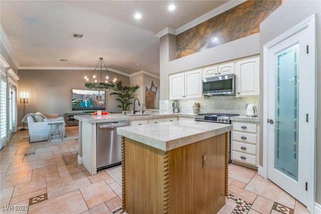 4014 Trapani Pl, Las Vegas, NV 89141 - kitchen with stainless steel appliances, a peninsula, white cabinets, decorative backsplash, and crown molding