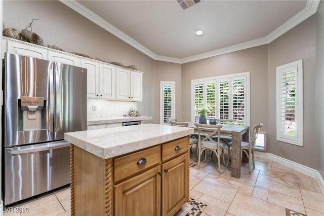 4014 Trapani Pl, Las Vegas, NV 89141 - kitchen featuring stainless steel refrigerator with ice dispenser, crown molding, white cabinets, a center island, and light stone countertops