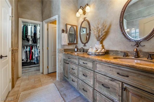 4014 Trapani Pl, Las Vegas, NV 89141 - bathroom featuring double vanity, a walk in closet, and stone tile floors