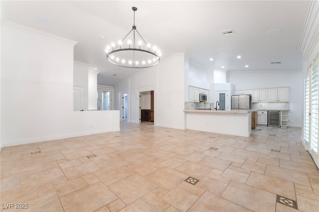4014 Trapani Pl, Las Vegas, NV 89141 - unfurnished living room with beverage cooler, crown molding, a chandelier, recessed lighting, and arched walkways